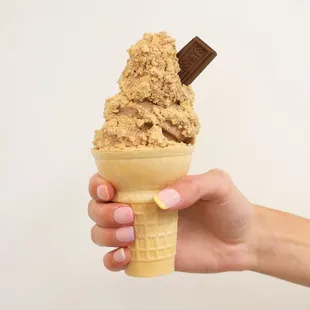 a hand holding an ice cream cone