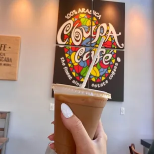 a hand holding a cup of coffee