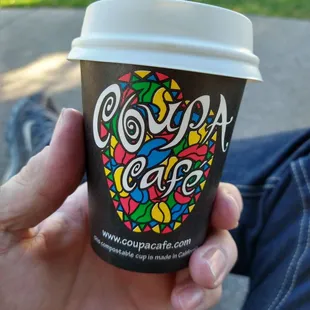 a hand holding a coffee cup