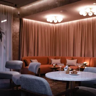 a living room with orange couches and a white table