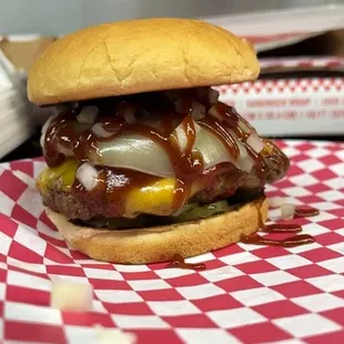 a cheeseburger on a checkered tablecloth