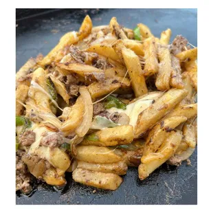 a pile of french fries with meat and cheese