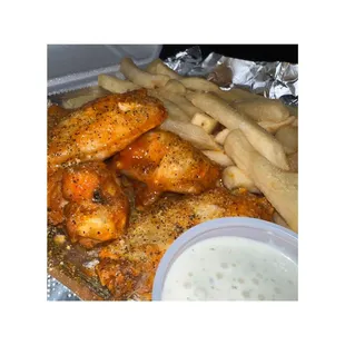 a plate of chicken wings and french fries
