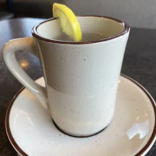 a cup of tea with a slice of lemon