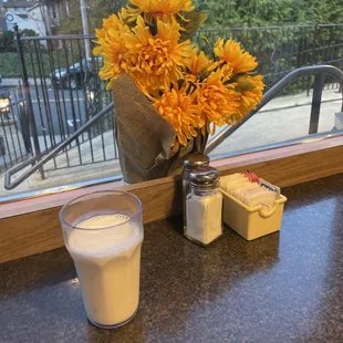 a vase of flowers and a glass of milk