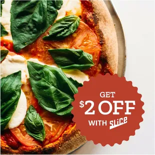 a pizza with spinach leaves on it