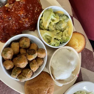 meatloaf with, fried okra, broccoli with cheese, mashed potatoes with white gravy and a side of salad plus cornbread, and a bread bun.