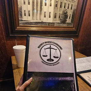 a woman holding up a menu