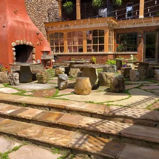 a patio with stone steps leading up to a fireplace