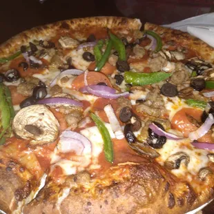 a pizza with mushrooms, peppers, and onions