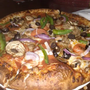 a pizza with mushrooms, peppers, and onions