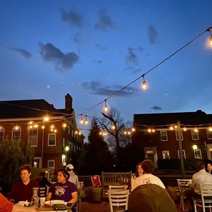 a group of people sitting outside at a restaurant