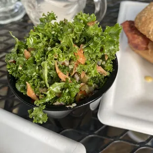 a bowl of kale salad and a sandwich
