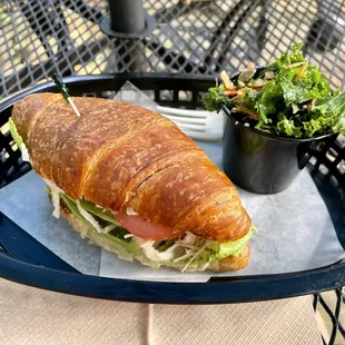 Turkey sandwich on croissant with signature kale salad.