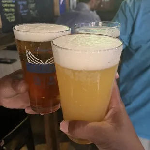 two people holding glasses of beer