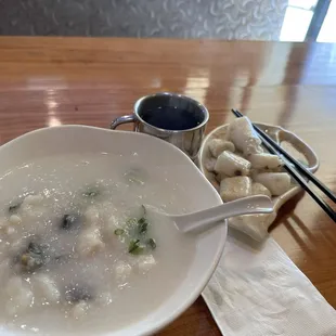 Fish and preserved egg porridge and side of rolled rice sheet.