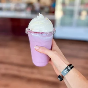 a hand holding a cup of ice cream