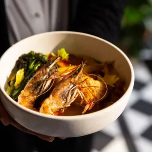 a person holding a bowl of food