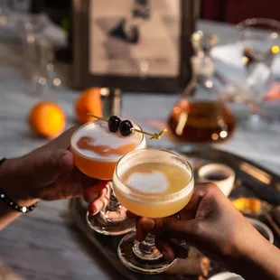 two people toasting with drinks