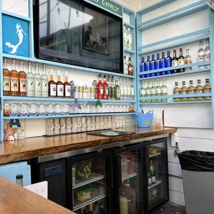 a bar with a television and shelves of liquor