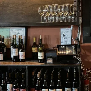 a shelf of wine bottles and glasses