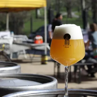 a glass of beer sitting on a keg