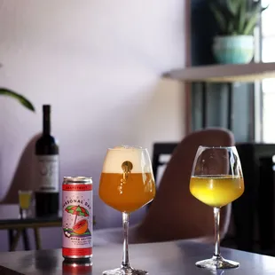 two glasses of beer and a can of beer