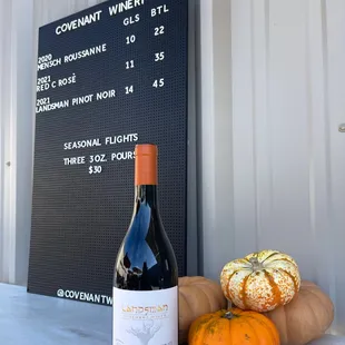 a bottle of wine and pumpkins