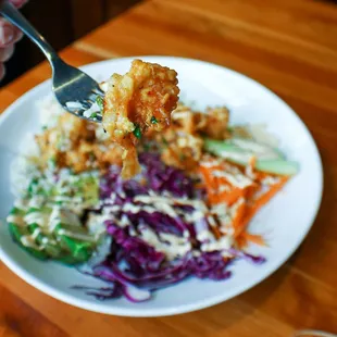 a person holding a fork over a plate of food