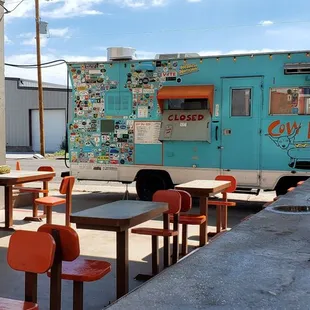 a blue food truck parked in front of a restaurant