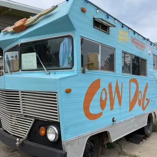 a blue food truck parked in front of a building
