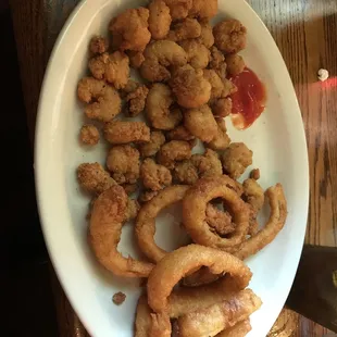 a plate of fried calamails and onion rings