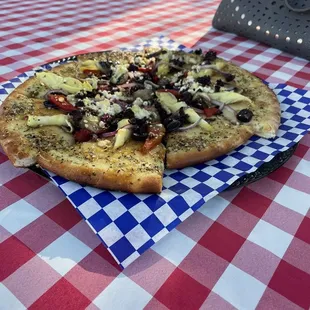 a pizza on a checkered tablecloth