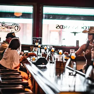 a man in a cowboy hat drinking a beer