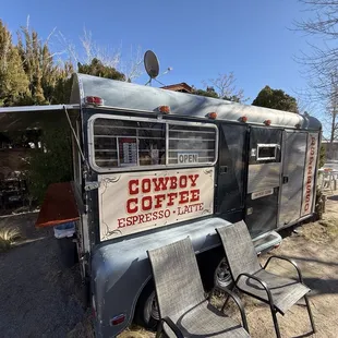 Charming Cowboy Coffee trailer serving gourmet espresso with cozy outdoor seating and rustic western flair.