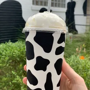a hand holding a cup of milk