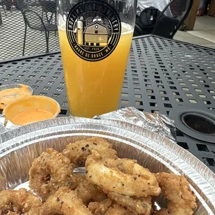 a plate of fried onion rings and a glass of beer