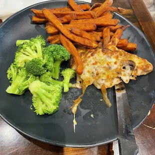 Smothered Chicken with sweet potato fries and seasonal vegetables
