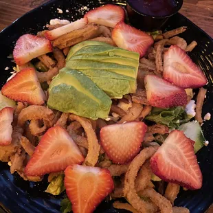 strawberry salad with onion strings and avocado added