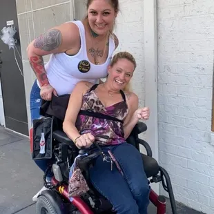 a woman in a wheelchair with a tattooed arm
