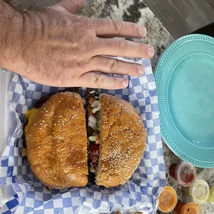 a hand reaching for a burger