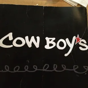 a cow boy's sign on a table