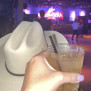 a cowboy hat and a drink