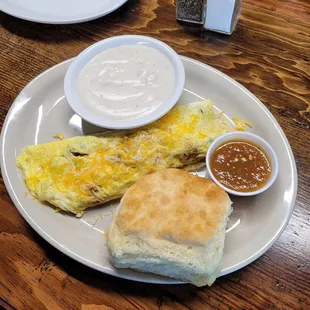 Sausage and cheese omlete with a biscuit and gravy.