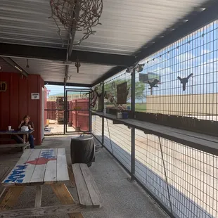 ows a woman sitting on a bench in front of a fenced in area