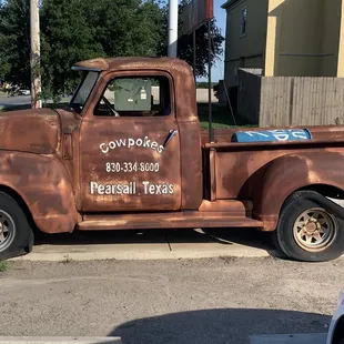 ows an old truck parked on the side of the road