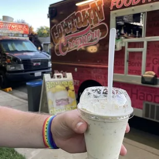 a hand holding a cup of milkshake
