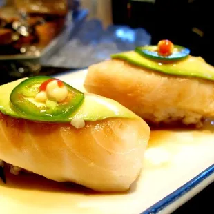 Super white tuna topped with avocado and a jalepeno and some soy sauce. Eat quickly before rice crumbles.