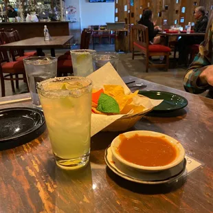 a drink and a bowl of soup on a table