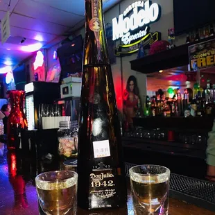 two shot glasses and a bottle of liquor